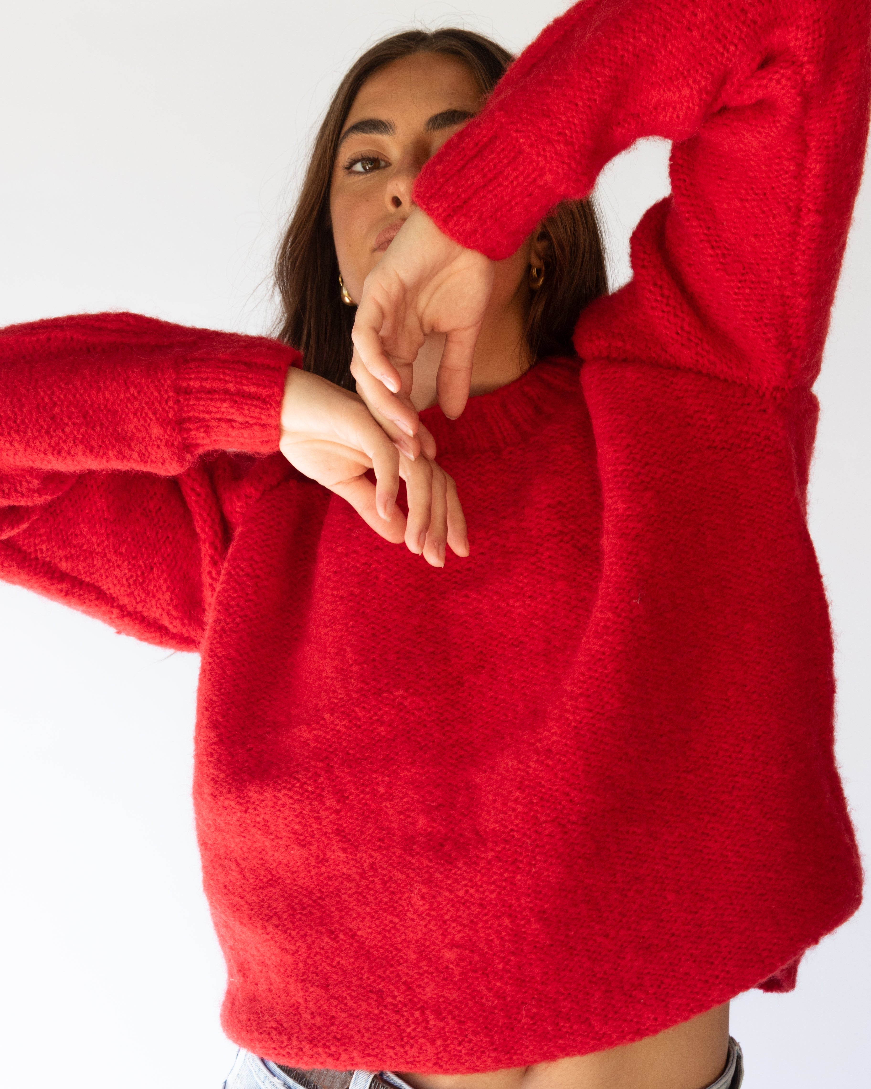 Person wearing a red sweater with a white background