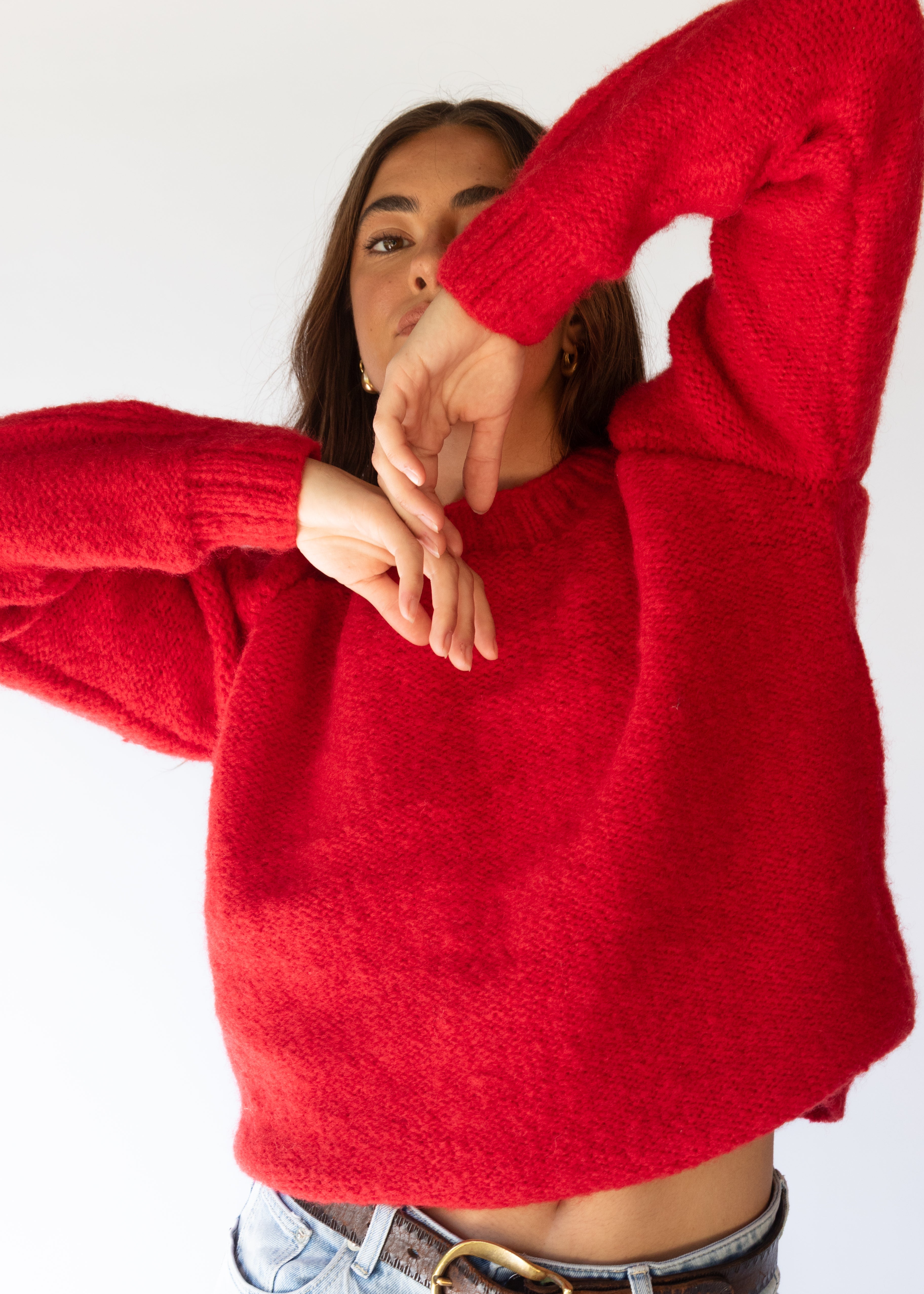 Person wearing a red sweater with a white background